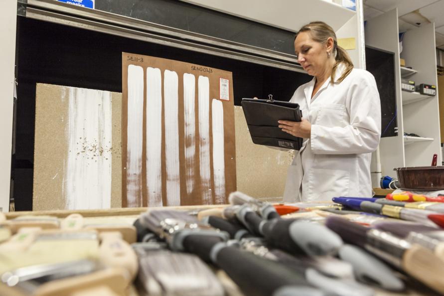 Laboratoriet testar färgspridning genom att dra vertikala streck så långt penseln släpper färg. Foto: Frazer Waller