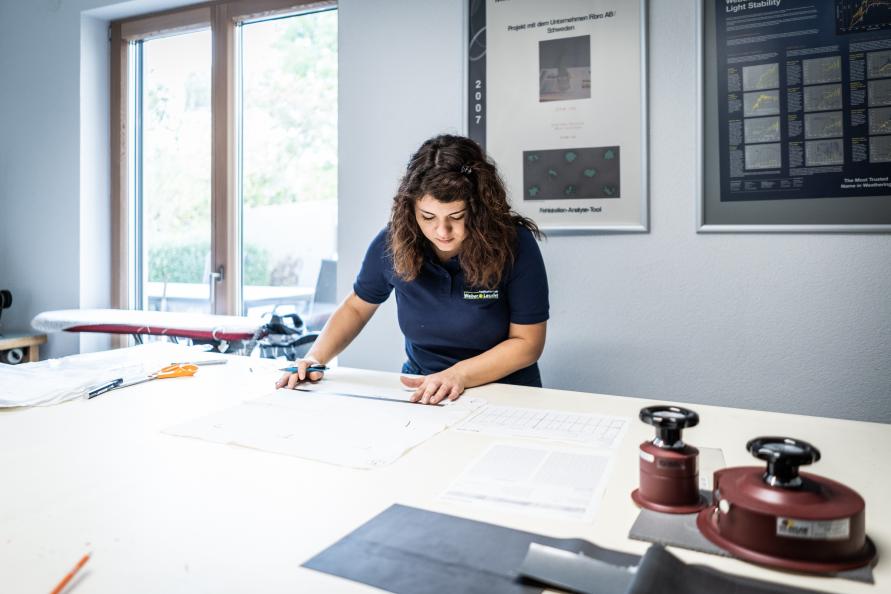 Laboratorieteknikern Veronica Occhipinti markerar på ett underlakan hur en provbit ska klippas ut. Foto: Peter Jülich. 